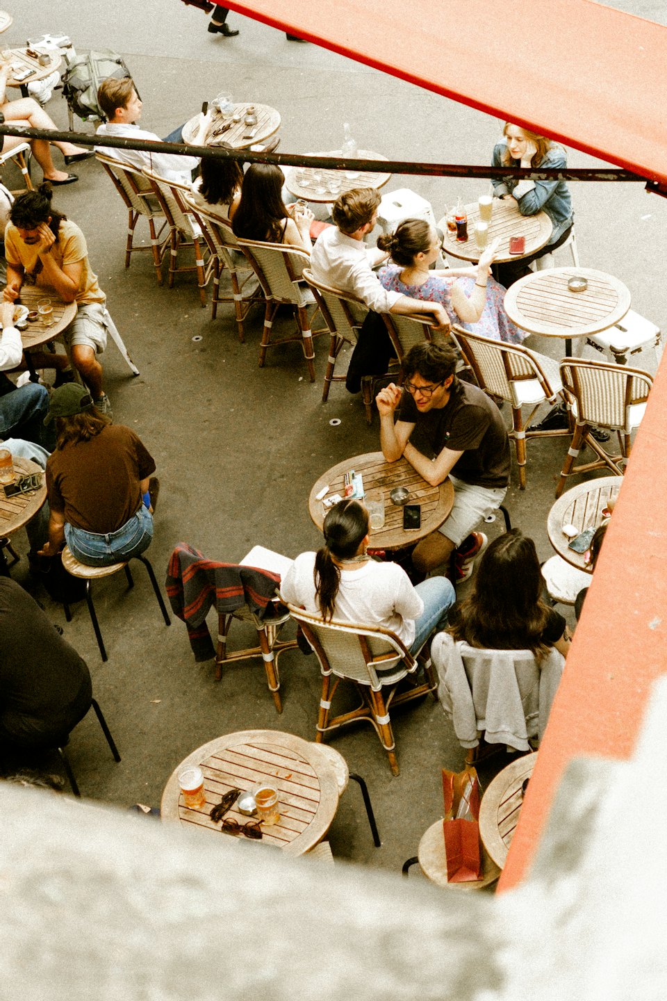 Jóvenes charlan y beben en una terraza.