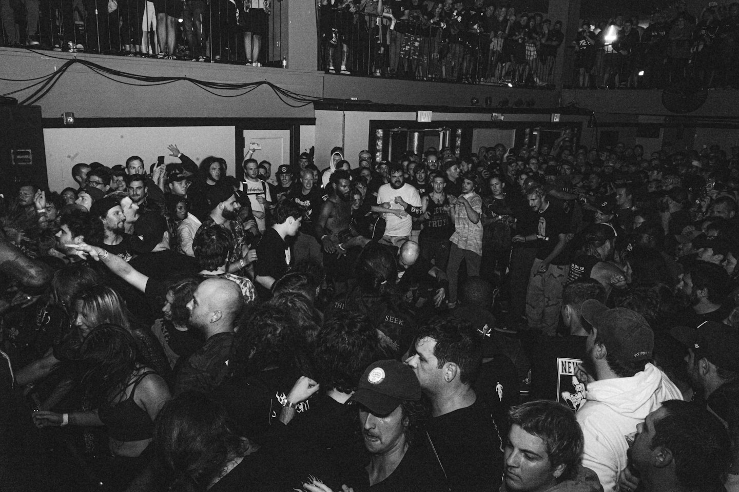 Asistentes a un concierto bailan en una sala de música interior abarrotada.